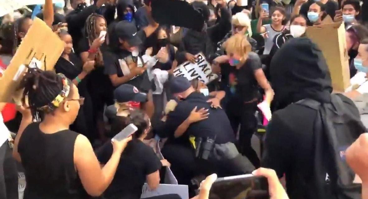 Agente de Policía abraza a manifestante durante una protesta en California por la muerte de George Floyd  (VIDEO)